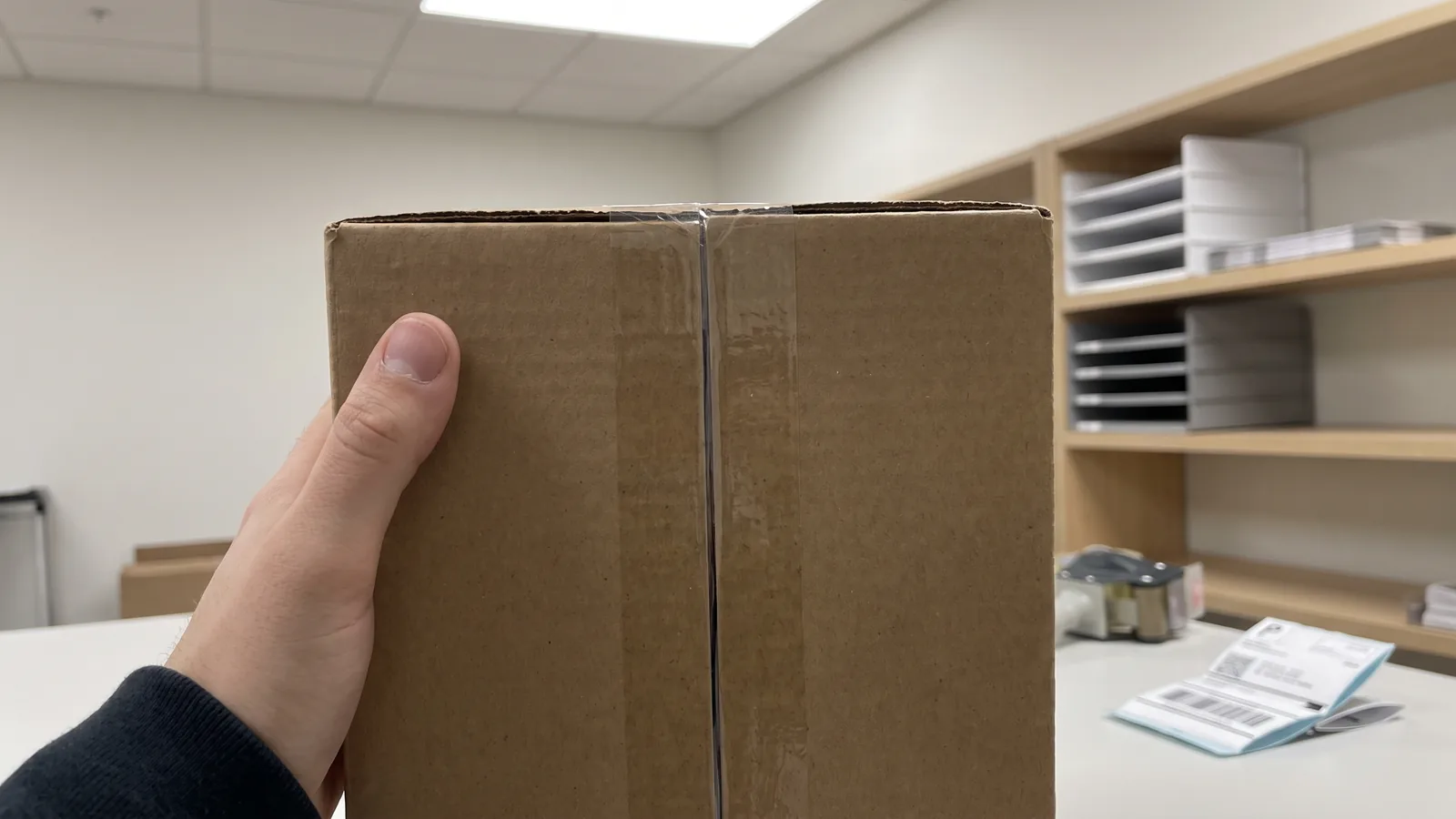 Tape that is still intact and unpeeled at the seam: useful, but on its own it says nothing about what went in before the box was sealed.